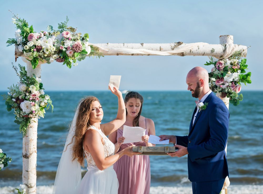 Newlyweds walking along the waterline at Upham Beach